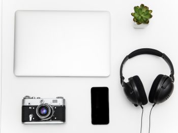 Top view of laptop, blank screen smartphone, vintage camera, headset and green flower on white background nidnoiit, nidnoiit.com, นิดหน่อยไอที, นิดหน่อย ไอที, ร้านนิดหน่อย, ขาย, จำนำ, ขายฝาก, มือสอง, สินค้ามือสอง, สินค้าไอที, โทรศัพท์มือถือ, Smartphone, iPhone, iPad, Tablet, Samsung, กล้องDSLR, กล้องmirrorless, โน๊ตบุ๊ค, Notebook, คอมพิวเตอร์, PC, ทีวี, TV, เครื่องเสียง, เกมPSP4, Nintendo, Gopro, iPadPro, IPhone4, IPhone5, IPhone5s, IPhone6, IPhone6s, IPhone7, IPhone8, IPhonex, IPhonexs, IPhonexsmax, IPhonexr, IPhone6plus, IPhone7plus, IPhone8plus, CANON, NIKON, LEICA, Fuji, SONY, OLYMPUS, PANASONIC, CASIO, Apple, Samsung, OPPO, Vivo, Huawei, Xiaomi Mi, Nokia, ASUS, LG, Wiko
